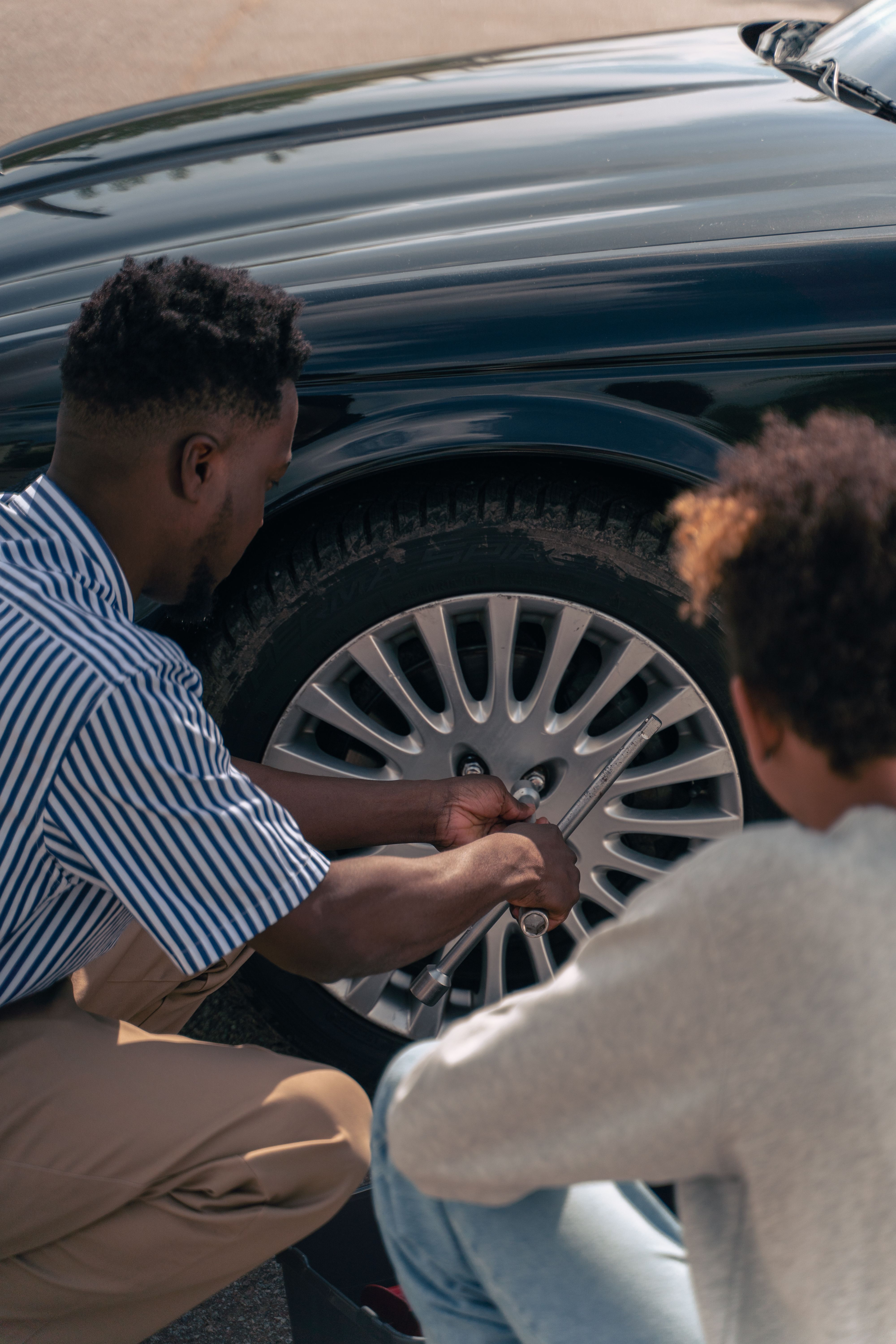 Technician jump starting a vehicle